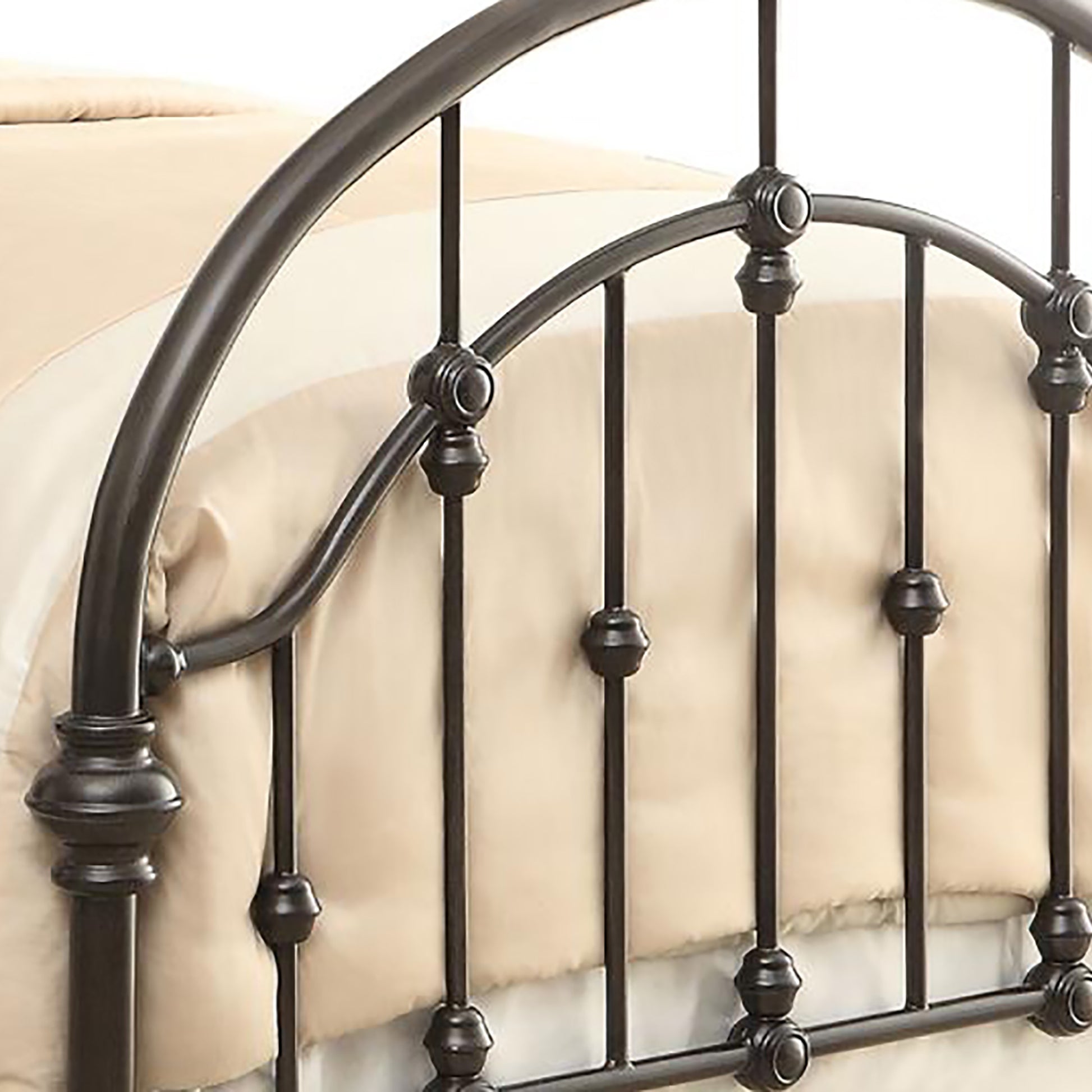 Dark brown wrought iron bed frame with arched headboard and decorative finials