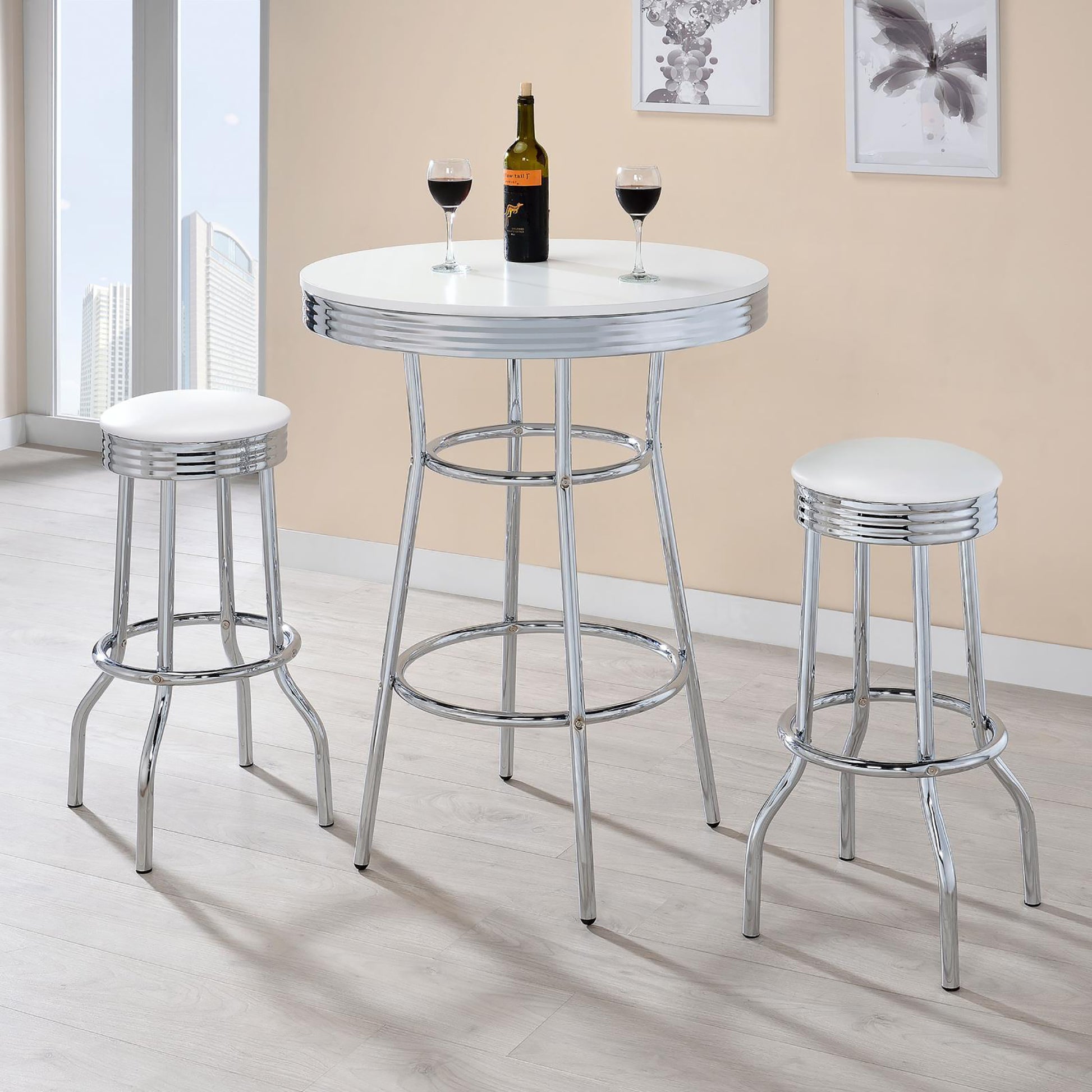 Retro chrome bar stools with white cushioned seats and a matching round table