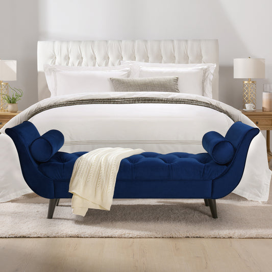 Navy velvet tufted chaise lounge with rolled arms and a cream throw