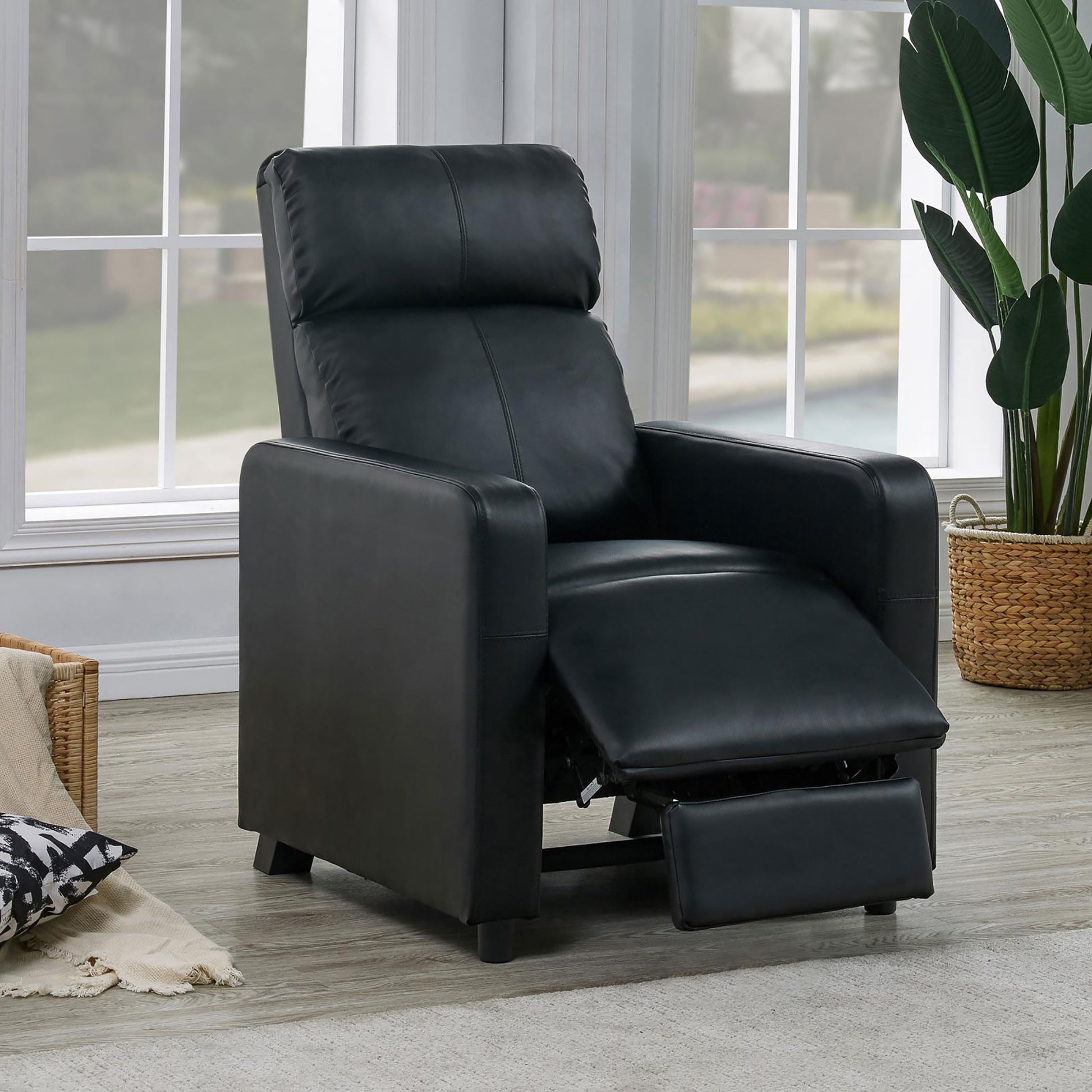 Black leather recliner with extended footrest perfect for living room relaxation
