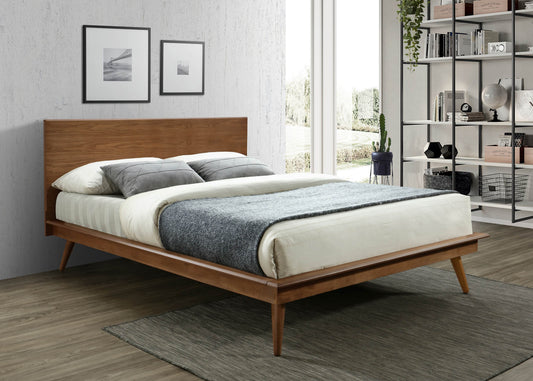 Midcentury modern wood platform bed frame with tapered legs and upholstered grey pillows