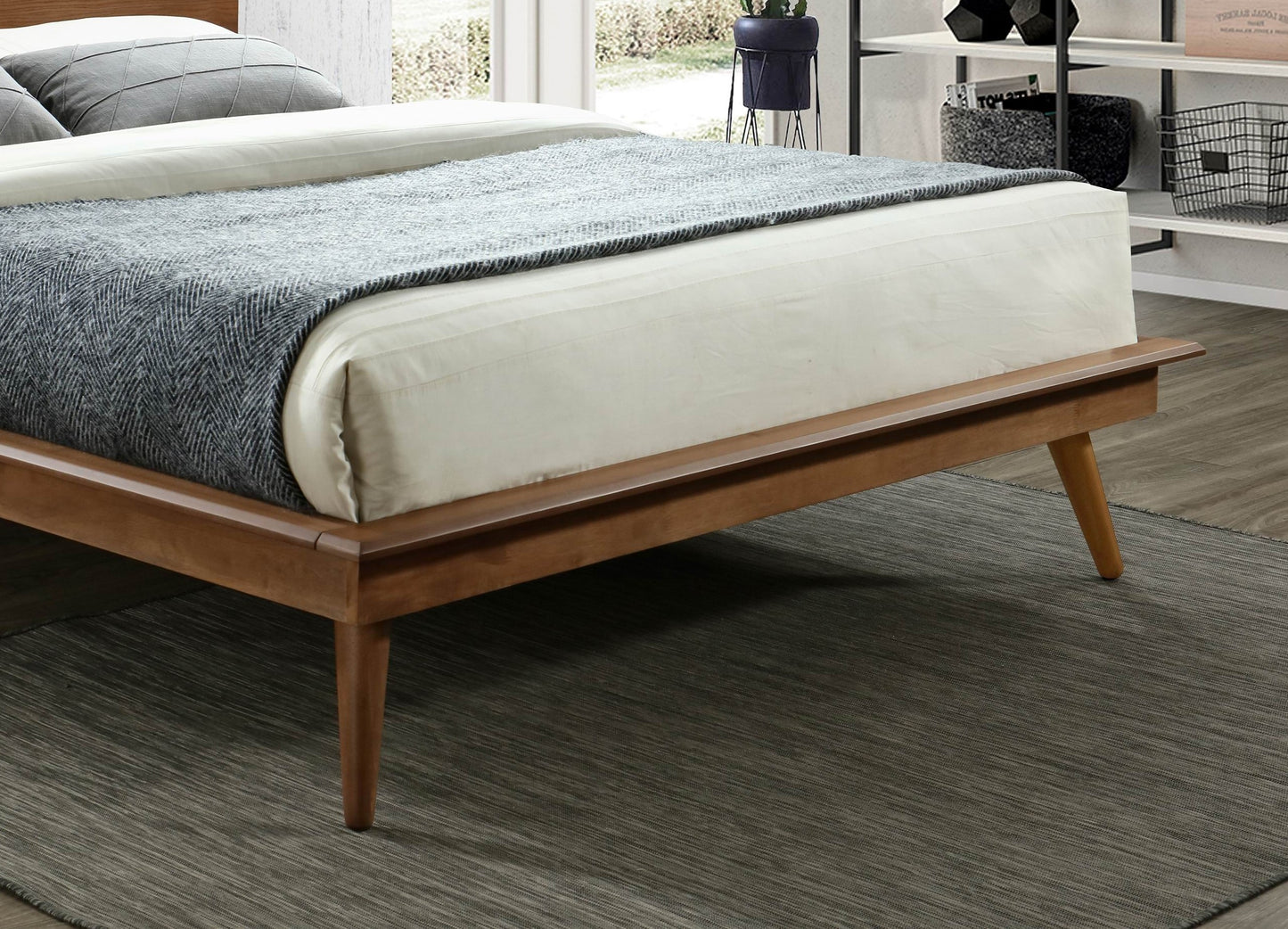 Minimalist wooden bed frame with tapered legs and white linens