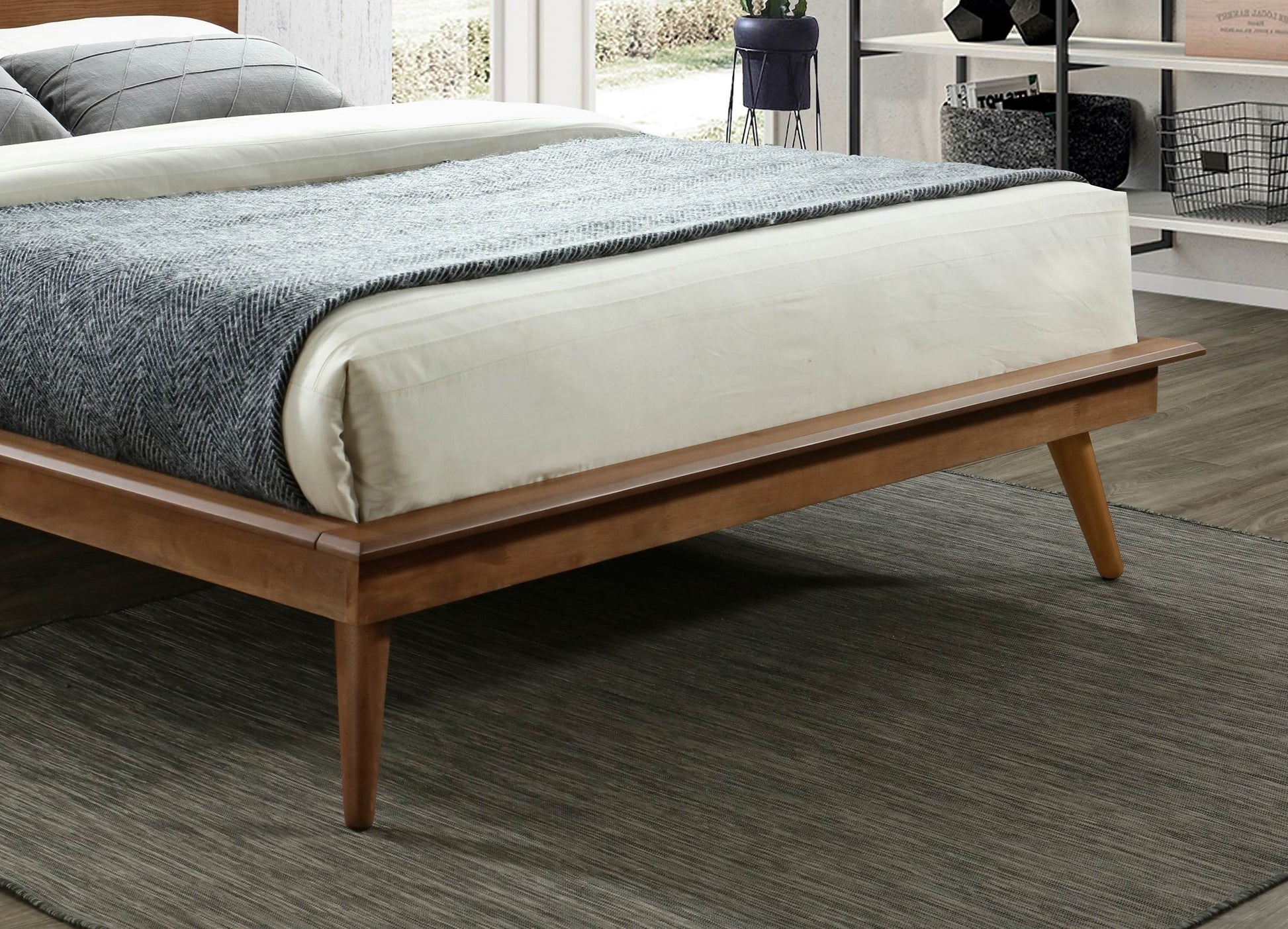 Minimalist wooden bed frame with tapered legs and white linens
