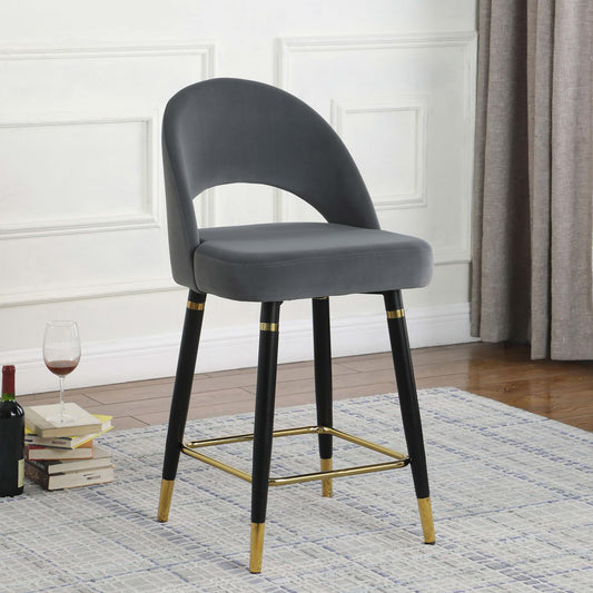 Grey velvet bar stool with black legs and gold accents