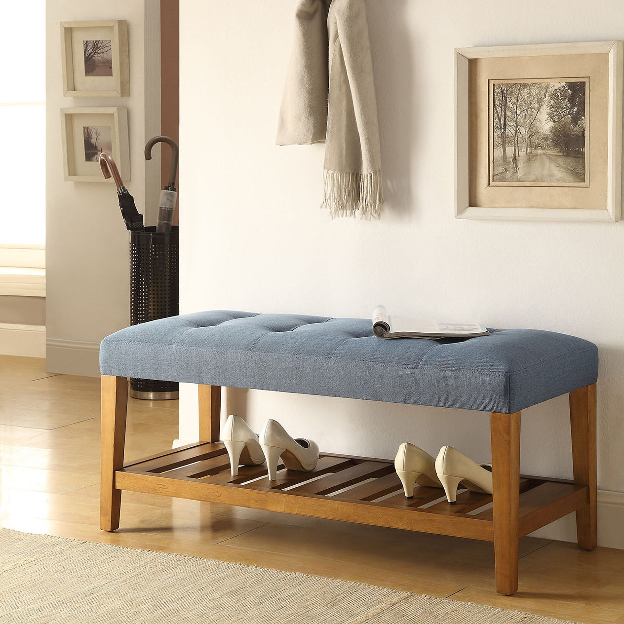 Tufted blue entryway bench with wooden legs and slatted shelf holding cream heels