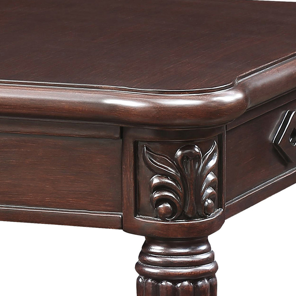Ornate dark wood writing desk with carved floral accents and turned legs