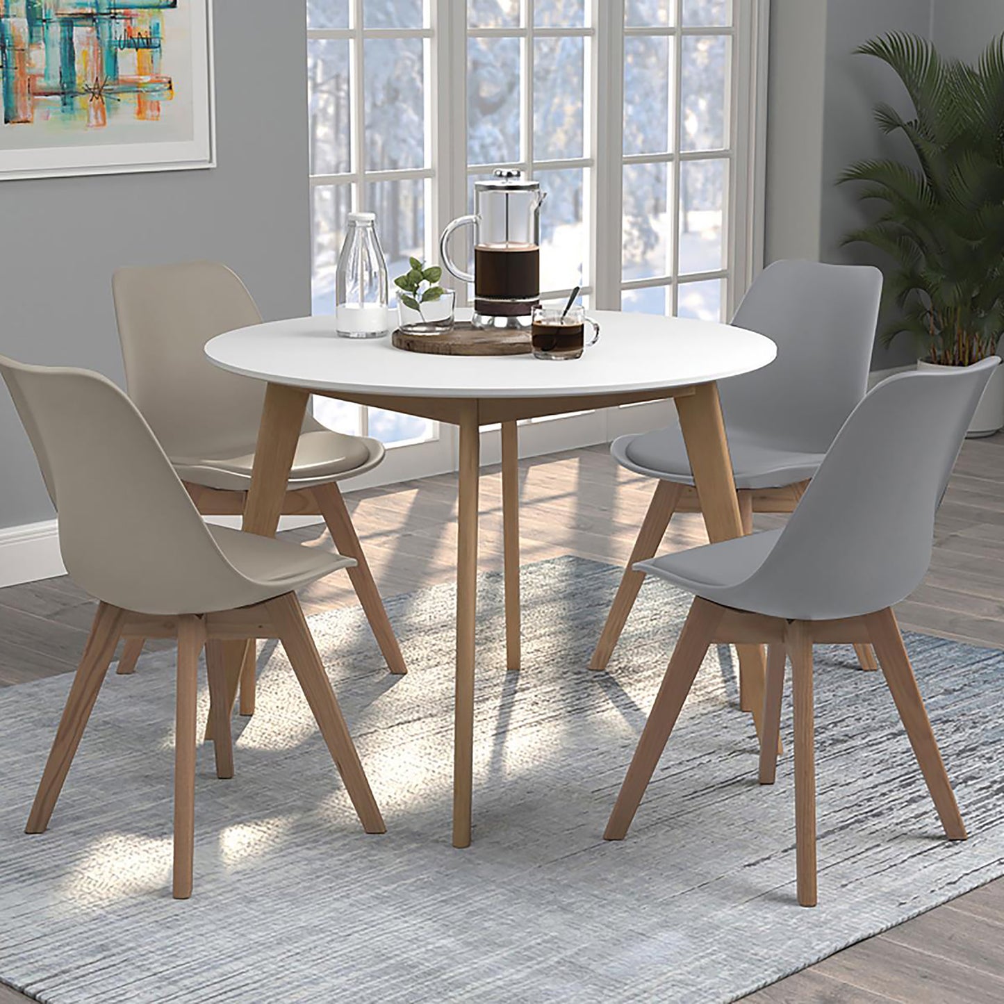 Modern white round dining table with four molded plastic chairs with wooden legs