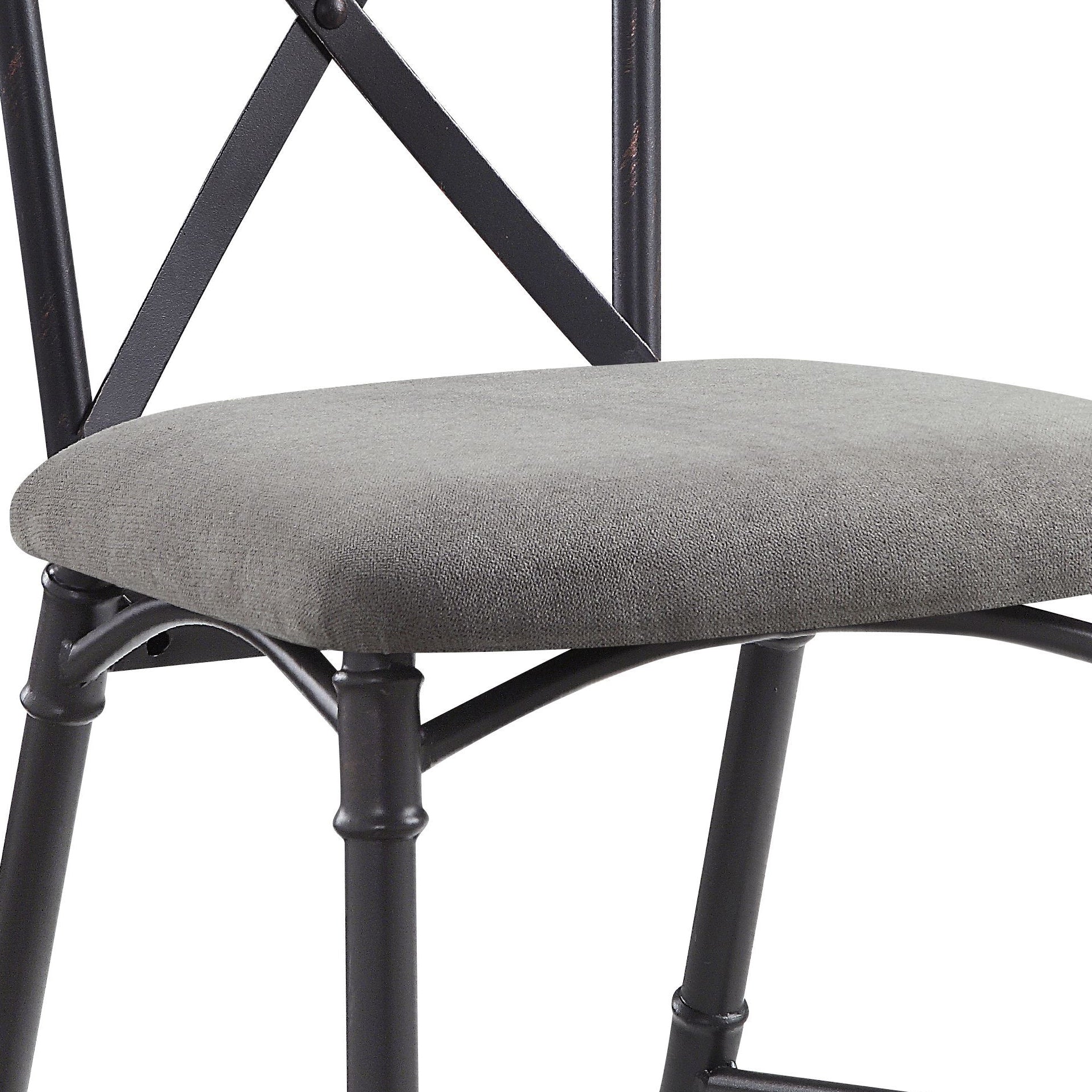 Closeup of upholstered gray seat on a rustic black metal chair with X back design