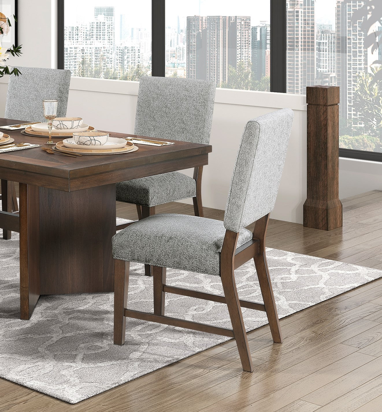 Gray upholstered counter stool with dark wood frame beside dining table
