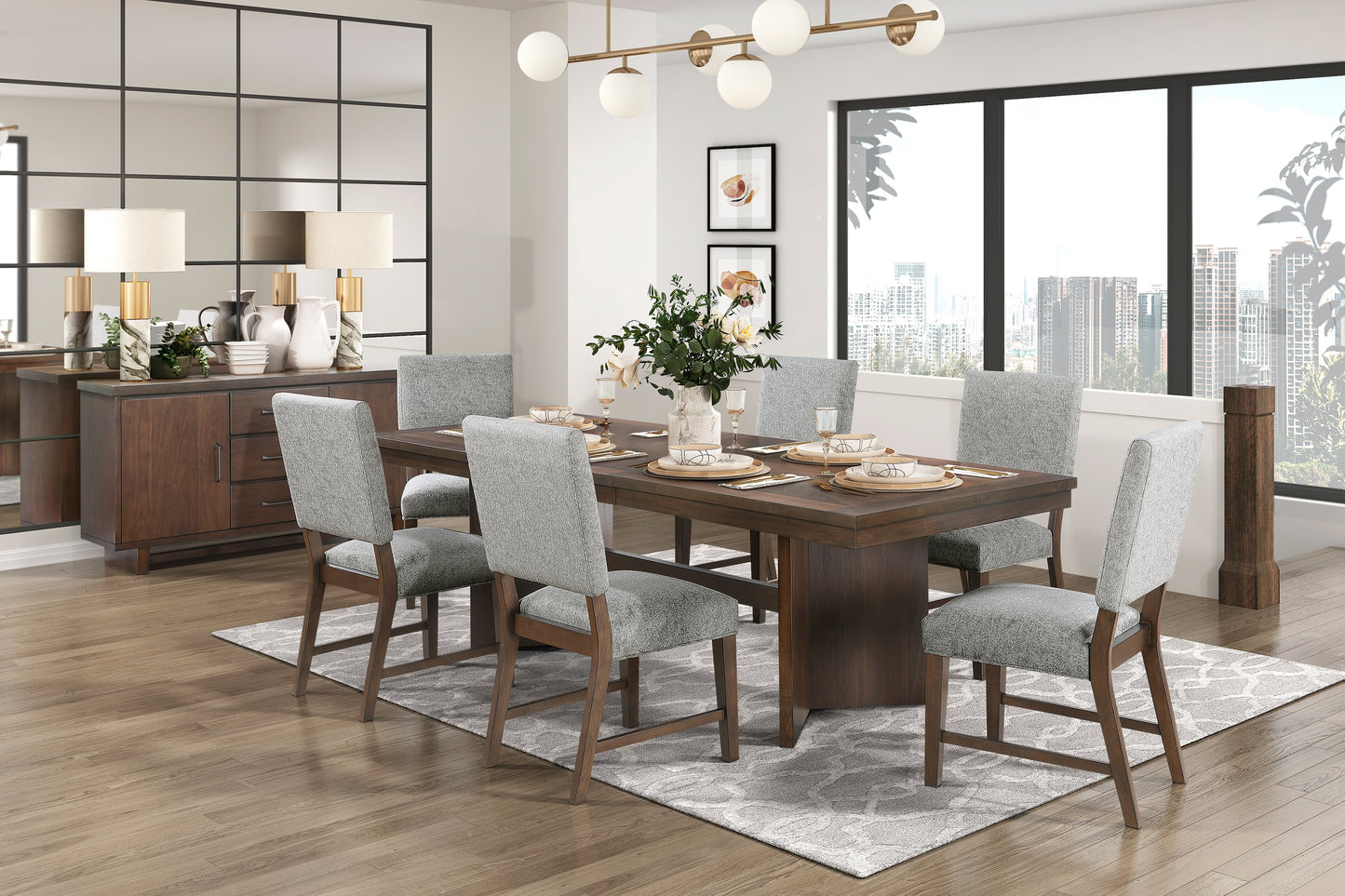 Dark wood dining table with six grey upholstered chairs set for a meal with place settings and floral centerpiece