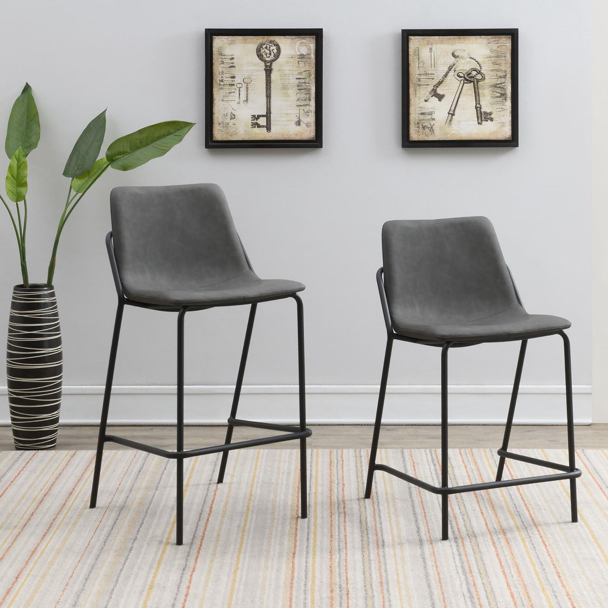 Two grey upholstered bar stools with black metal legs perfect for a modern kitchen island