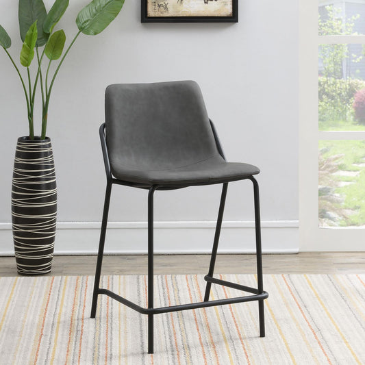 Gray faux leather bar stool with black metal legs on striped rug