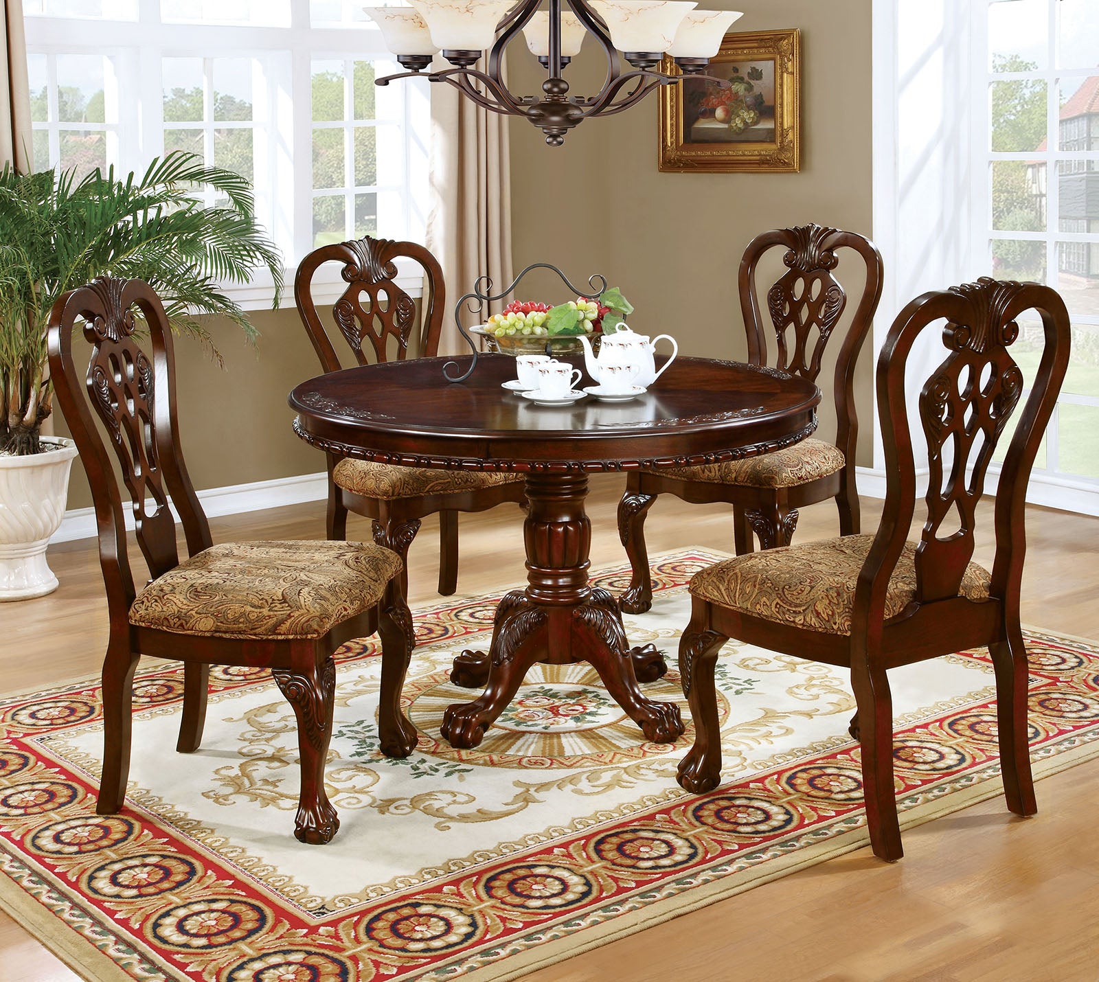 Ornate dark wood dining table with four carved chairs and upholstered seats