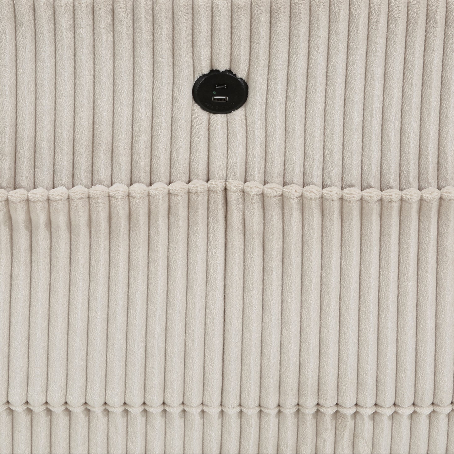 Closeup of beige corduroy fabric with a circular black USB charging port