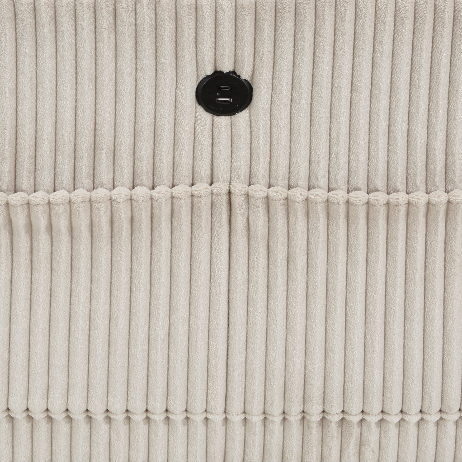 Closeup of beige corduroy fabric with a circular black USB charging port