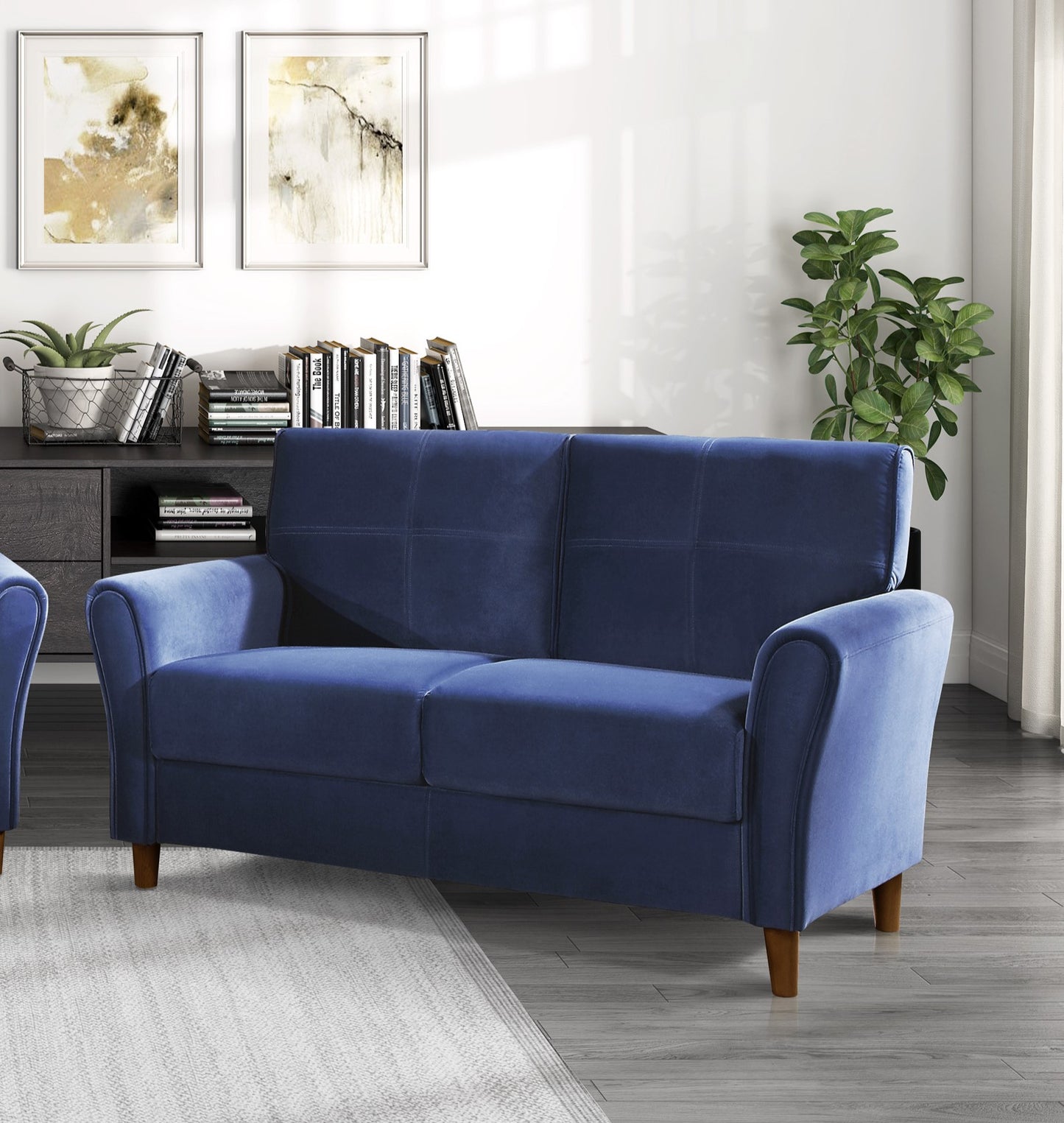 Deep blue velvet loveseat with cushioned tufted back and rolled arms