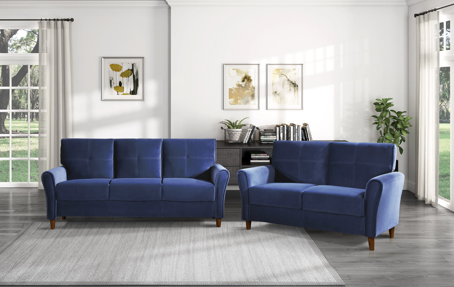 Navy blue upholstered sofa with tufted back cushions and rolled arms part of a living room set