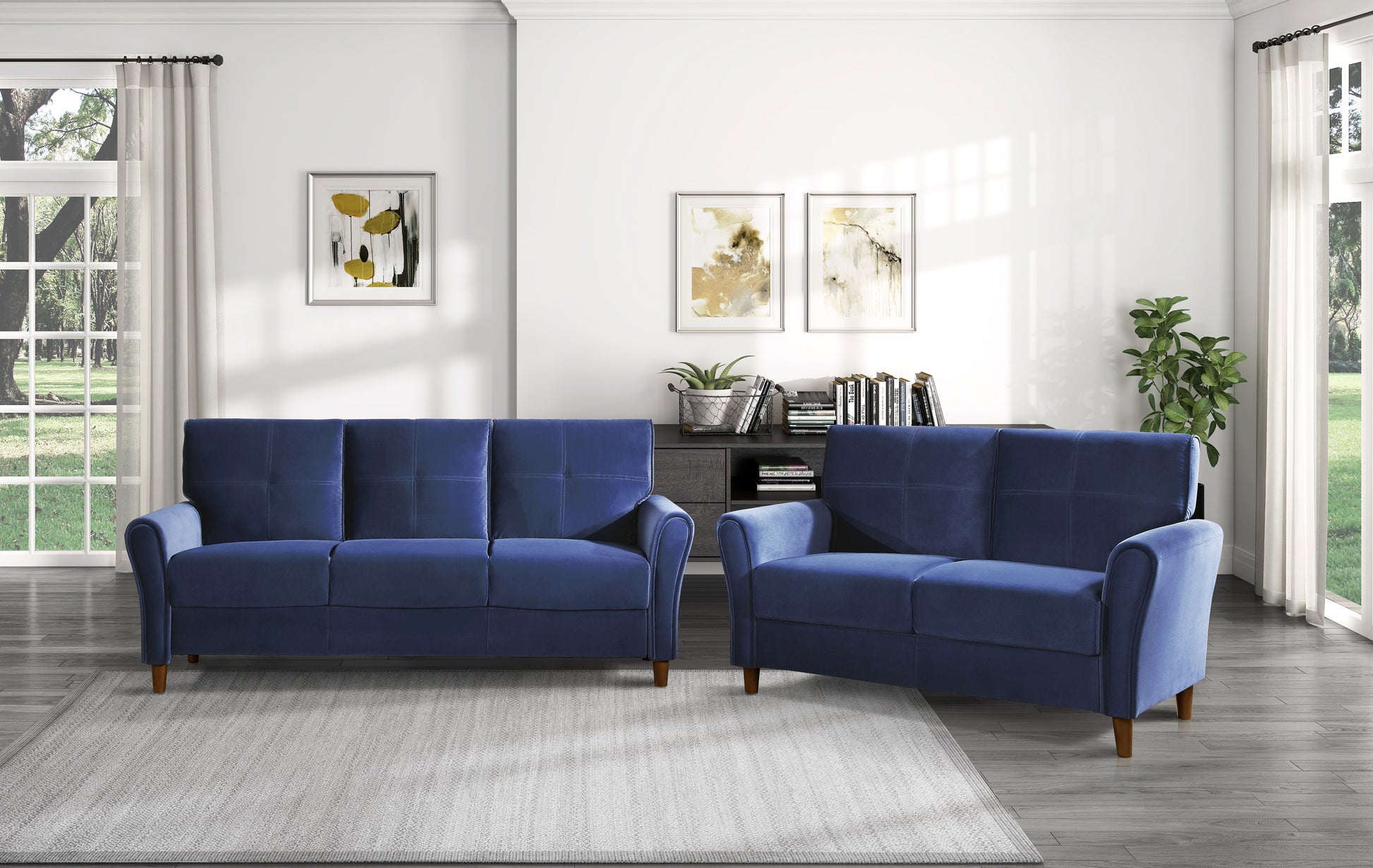 Navy blue upholstered sofa with tufted back cushions and rolled arms part of a living room set
