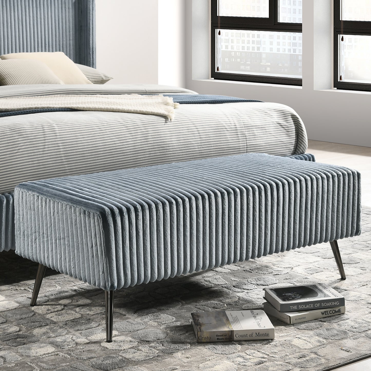 Dusty blue corduroy ottoman with channel tufting and metal legs