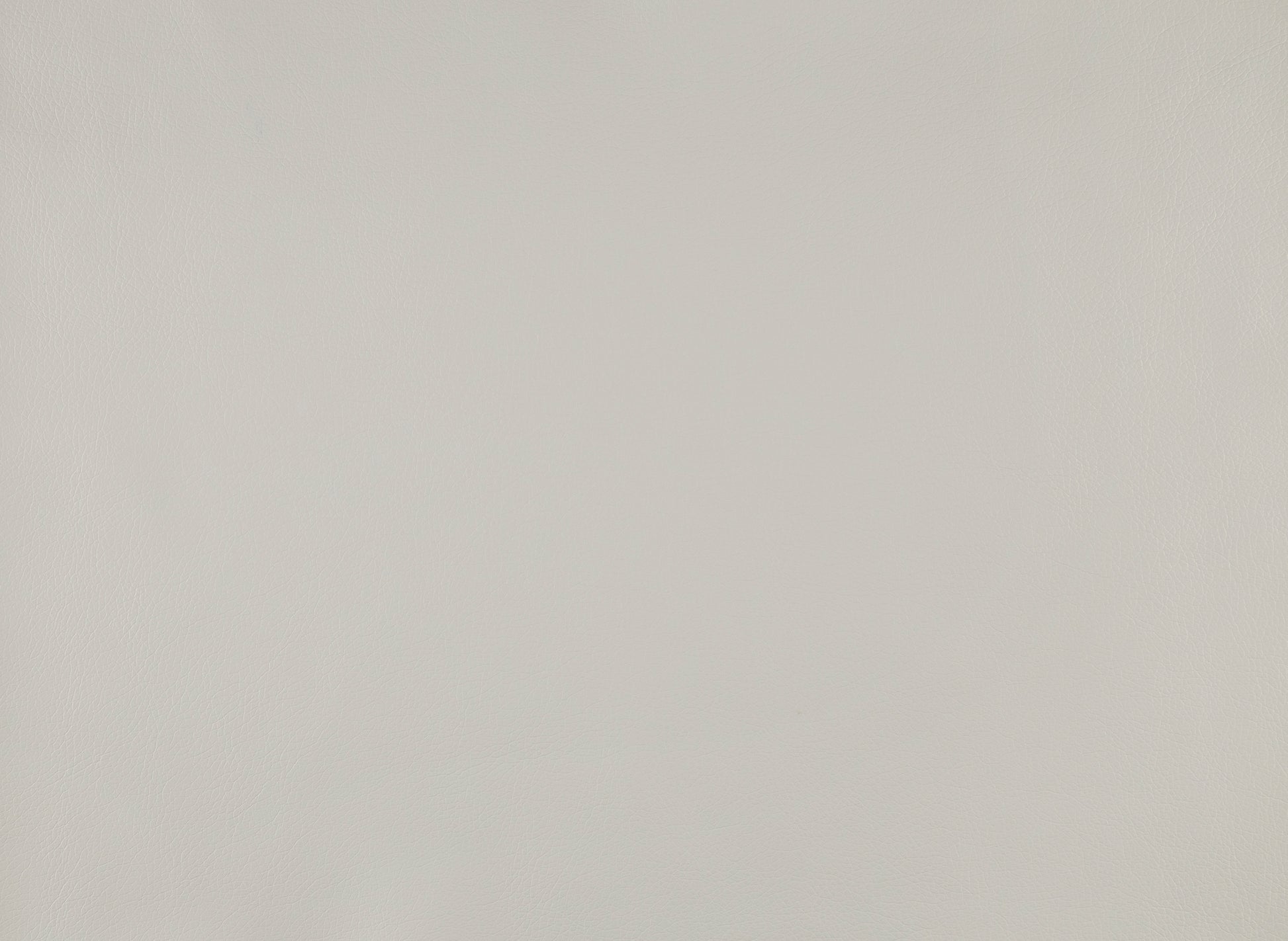 Closeup of smooth light grey faux leather fabric texture with subtle grain