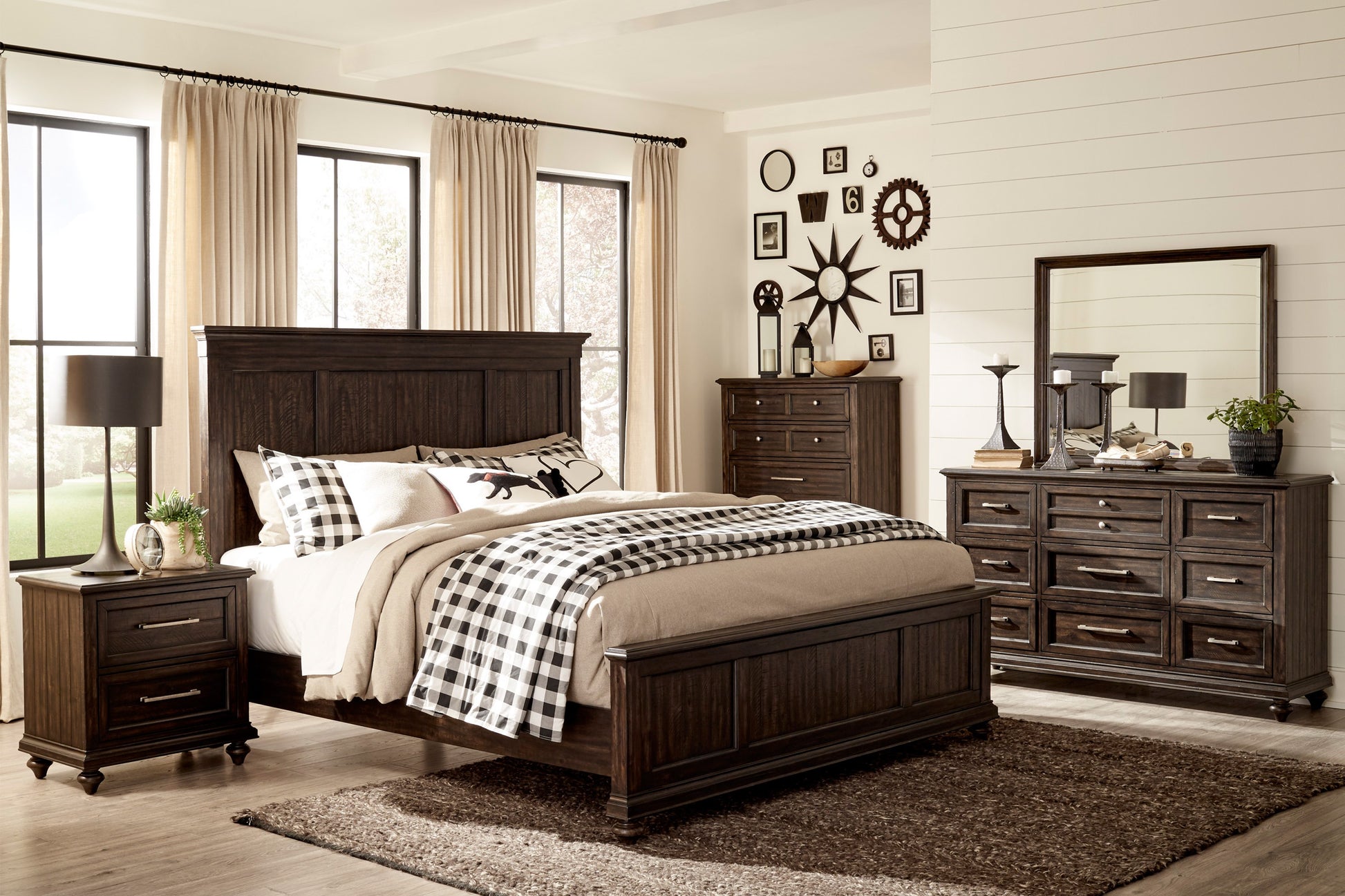 Dark brown wooden kingsize bed frame with plush bedding and buffalo check throw
