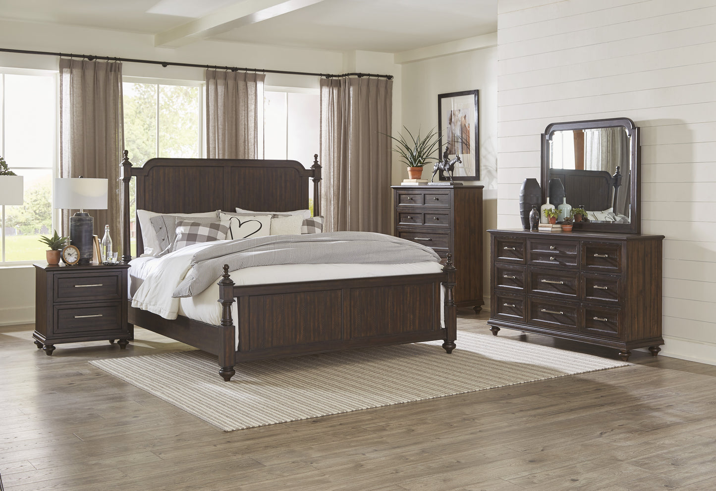Dark brown wooden king bed frame with ornate headboard and footboard styled with pillows and bedding