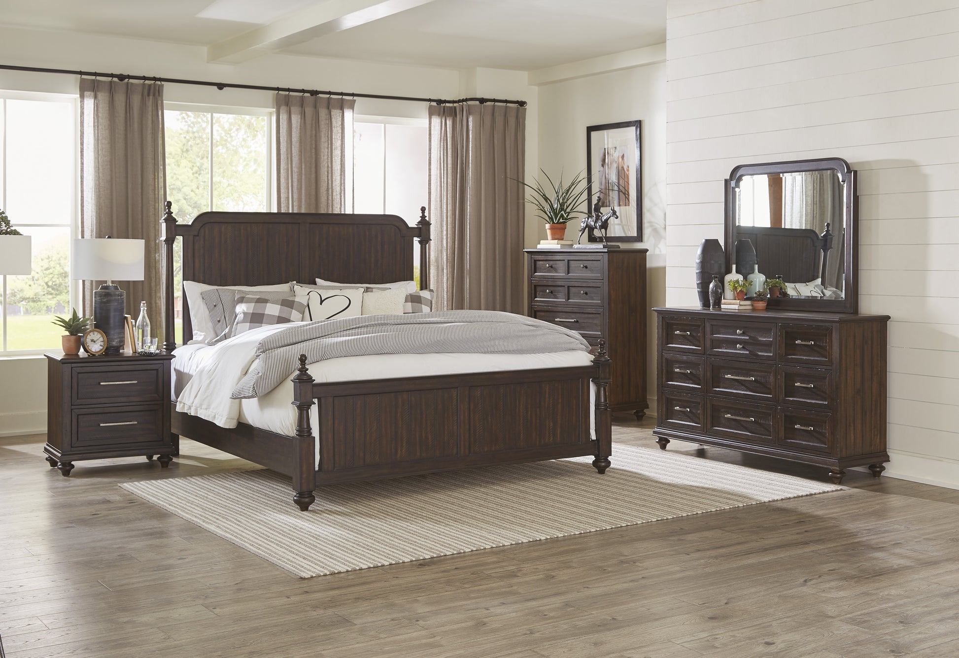 Dark brown wooden king bed frame with ornate headboard and footboard styled with pillows and bedding