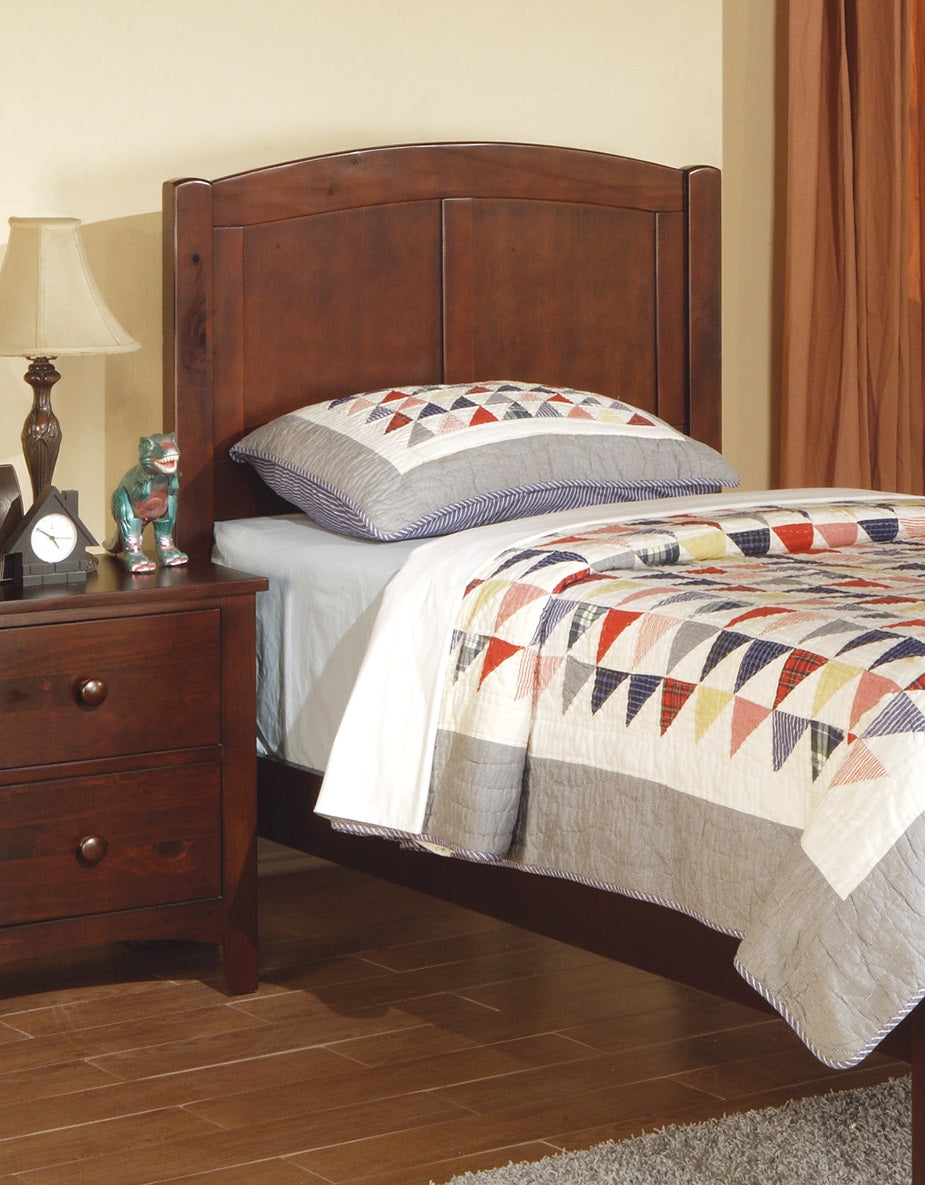 Classic dark wood headboard on a twin bed with a colorful geometric quilt
