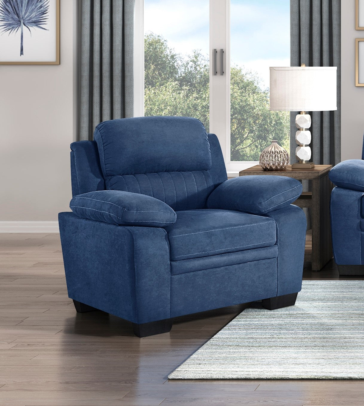 Plush navy blue upholstered recliner chair with detailed stitching and padded arms