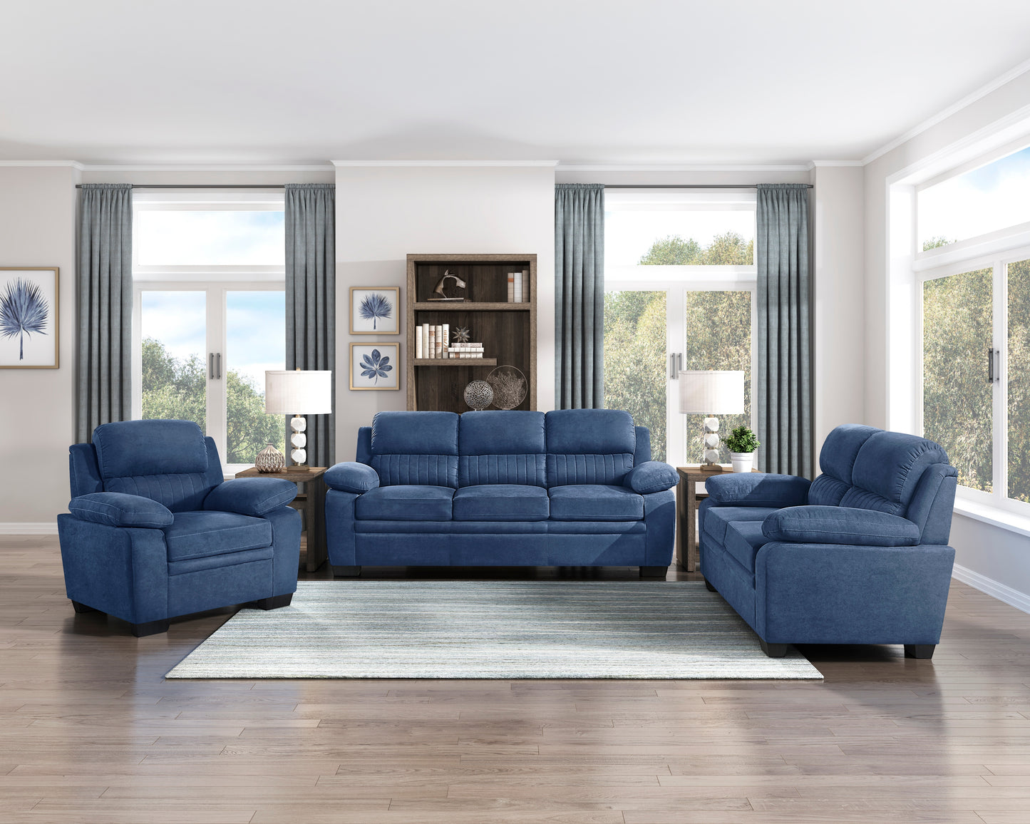 Threepiece navy blue upholstered living room set with sofa and two armchairs on a striped rug