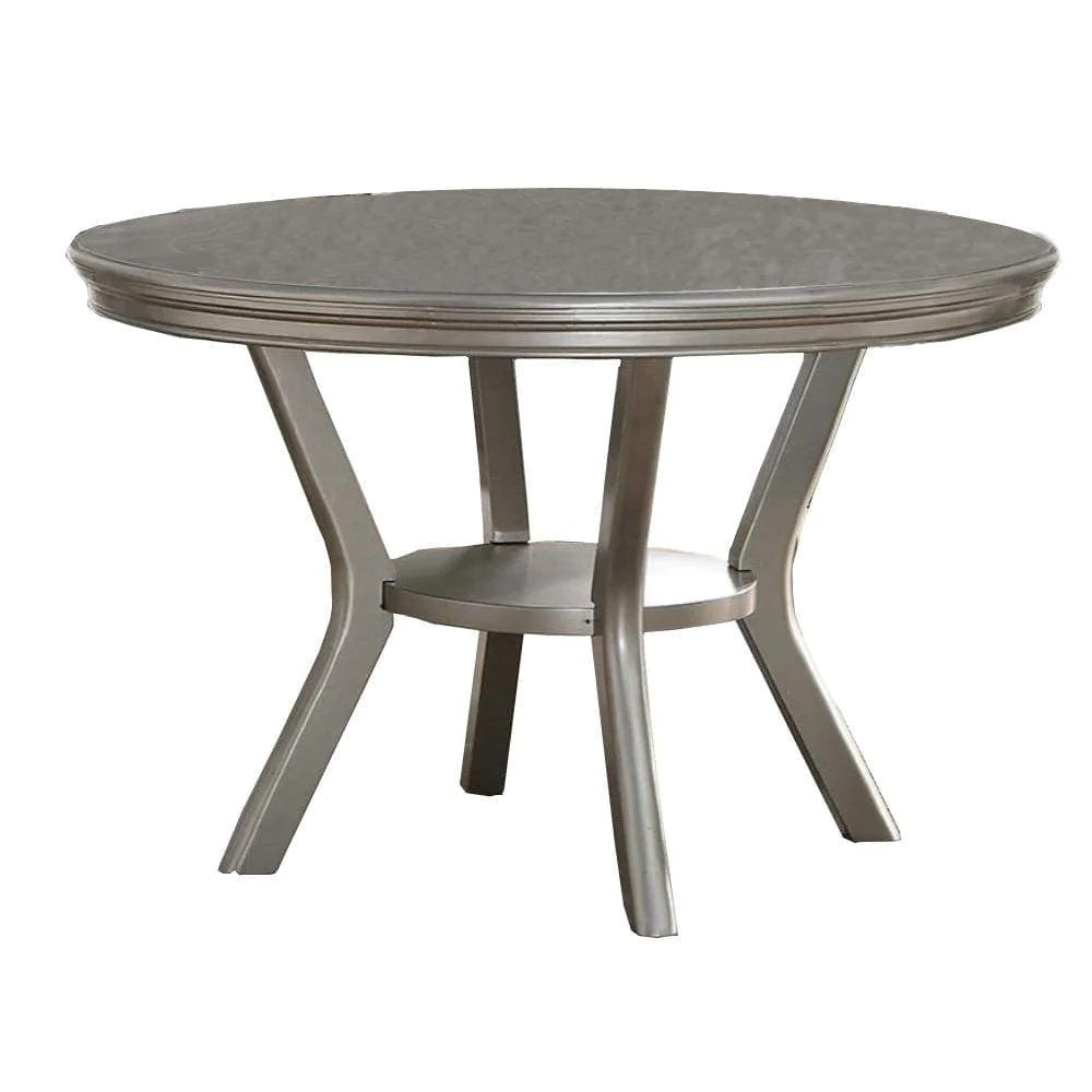 Round silver dining table with curved legs and a central shelf