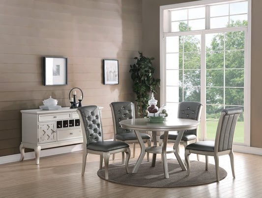 Elegant tufted dining chairs with crystal accents around a circular silver dining table