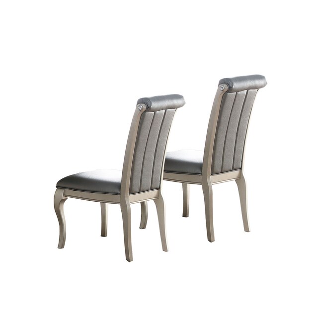 Two elegant grey upholstered dining chairs with tufted backs and ornate legs