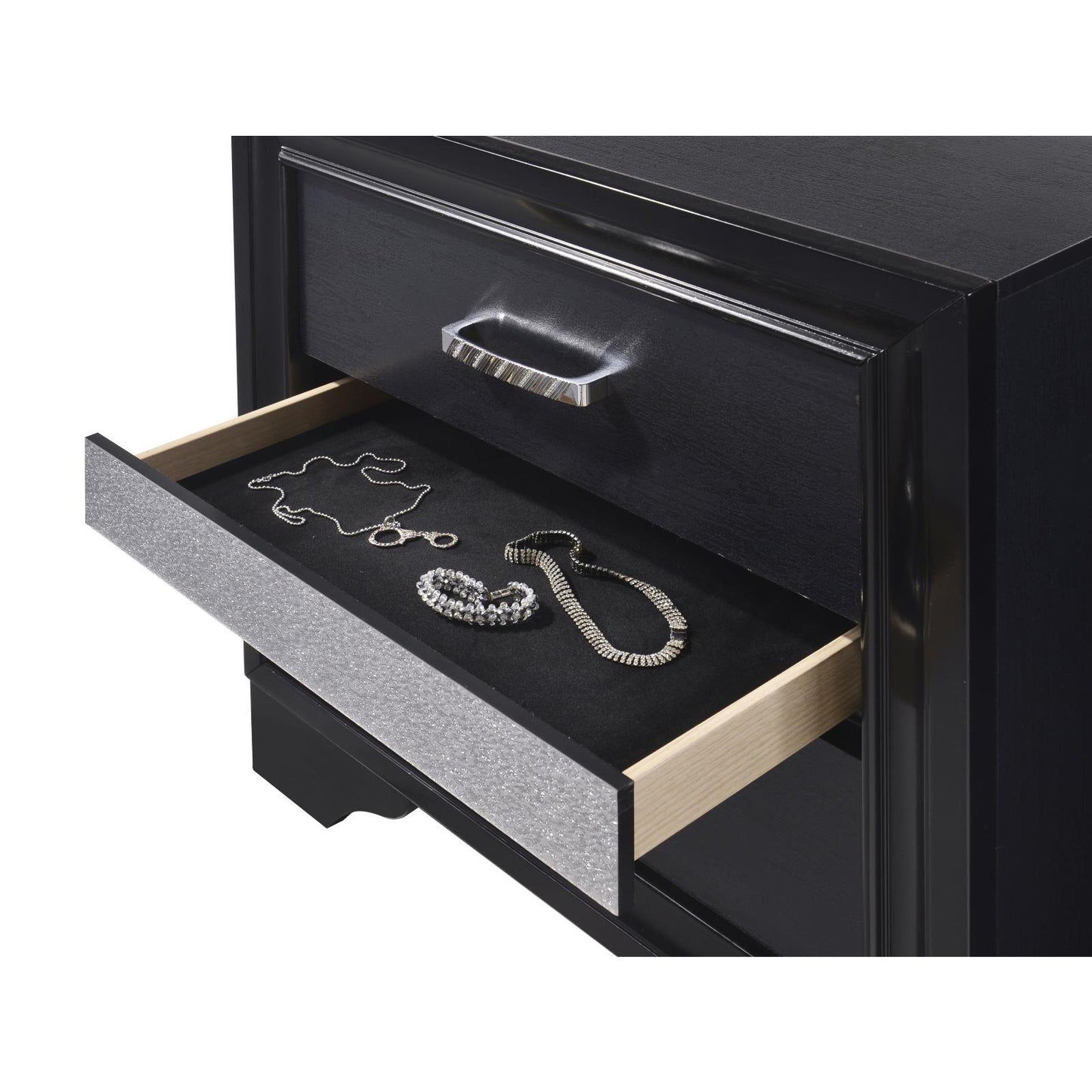 Black dresser with open drawer showcasing silver necklaces and bracelet
