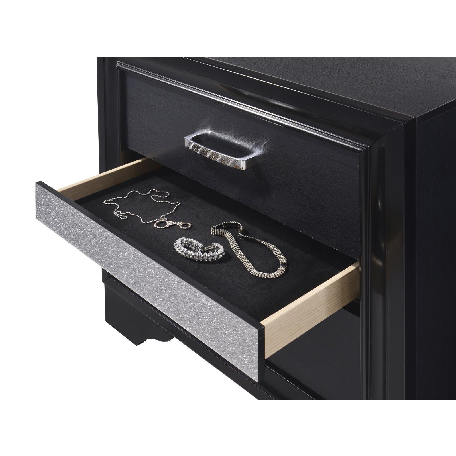 Black dresser with open drawer showcasing silver necklaces and bracelet