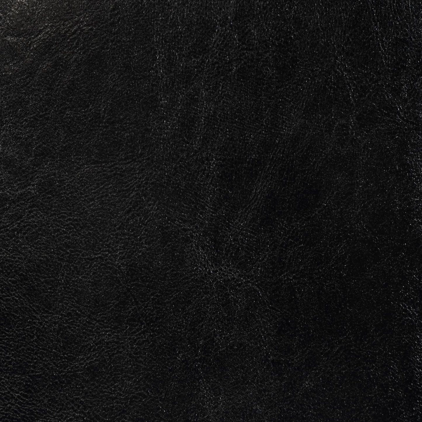 Closeup textured black leather material with subtle grain for luxury goods