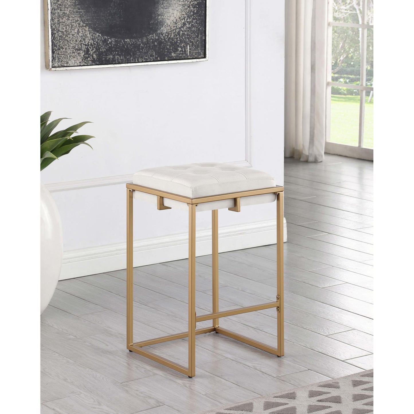 Gold frame bar stool with tufted white faux leather seat for a modern kitchen