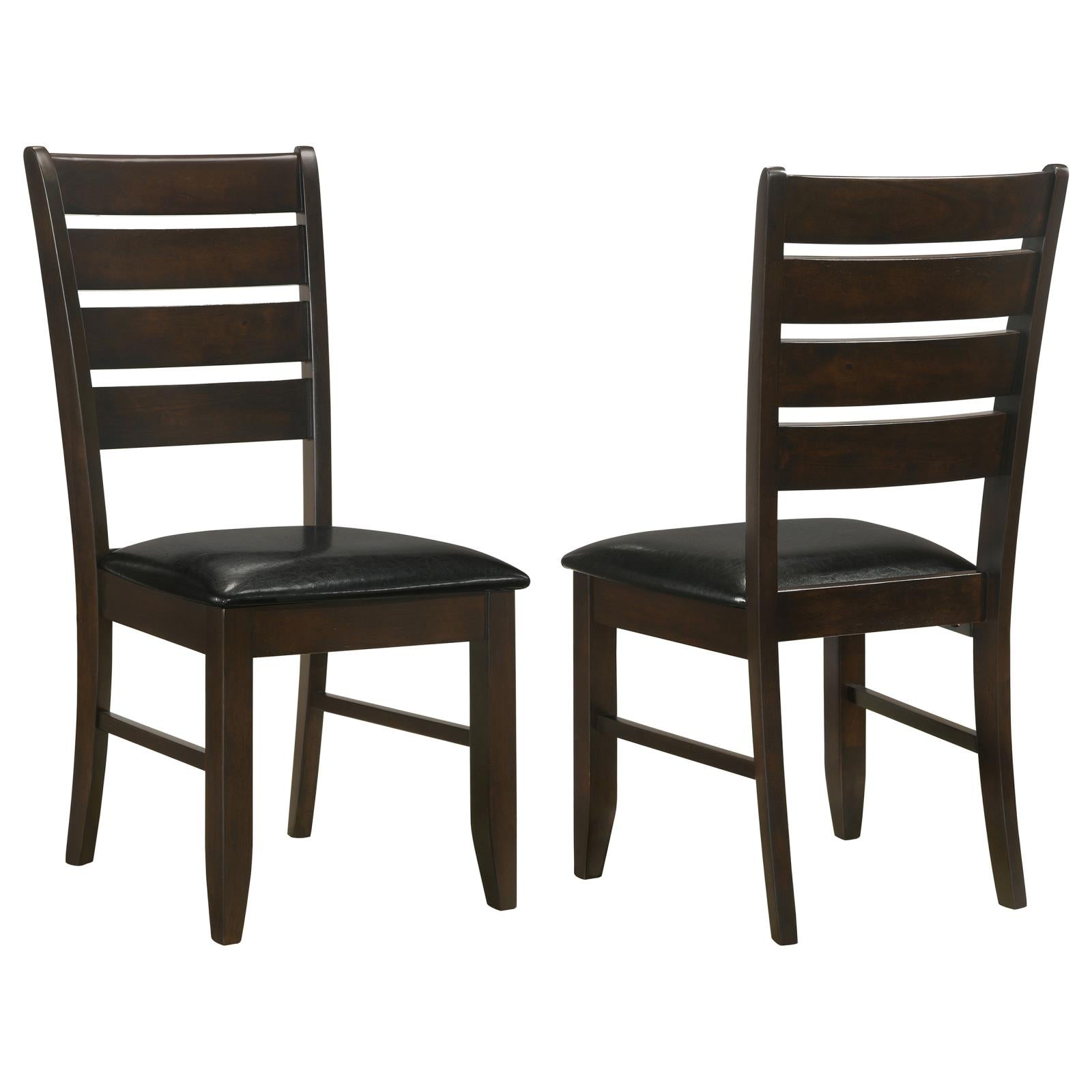 Two dark brown wooden dining chairs with black faux leather seats and ladder backs