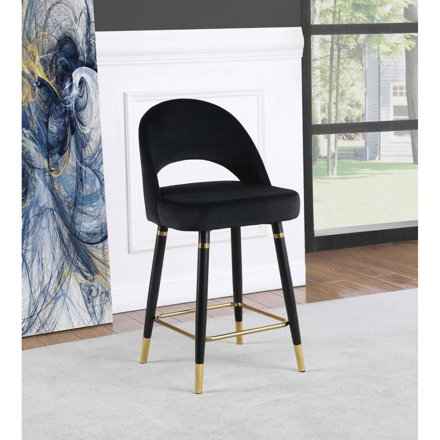 Black velvet counter stool with curved back and gold accents on legs