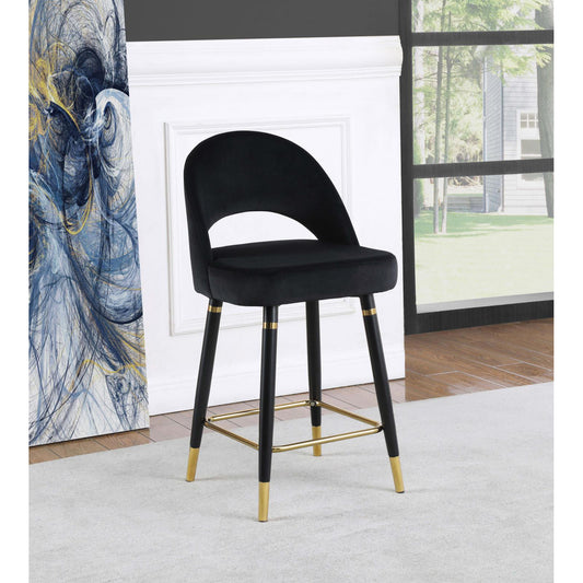 Black velvet counter stool with curved back and gold accents on legs