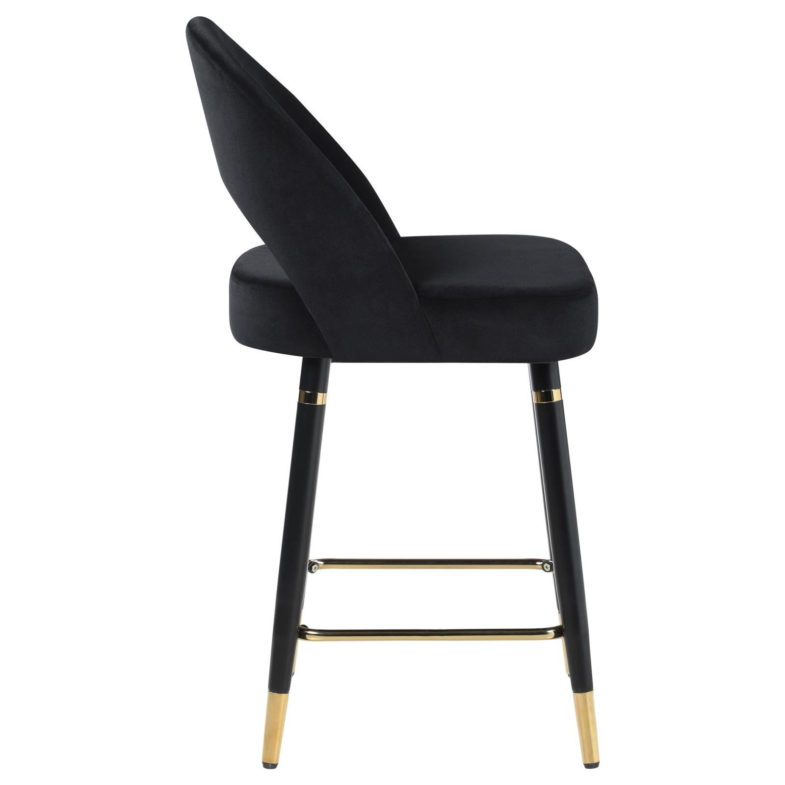 Black velvet bar stool with gold accents and black tapered legs for modern kitchens