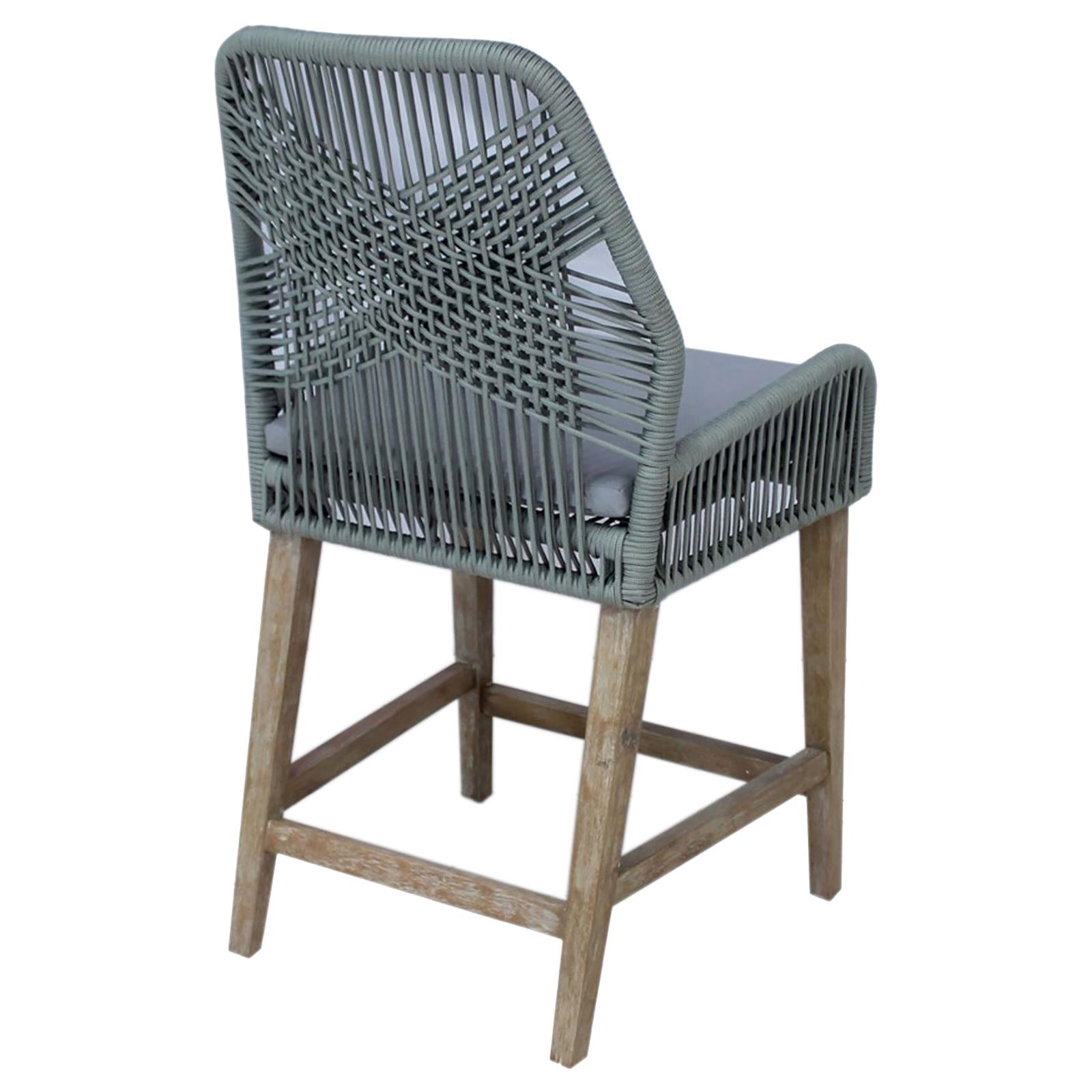 Gray woven outdoor bar stool with cushioned seat and natural wood legs