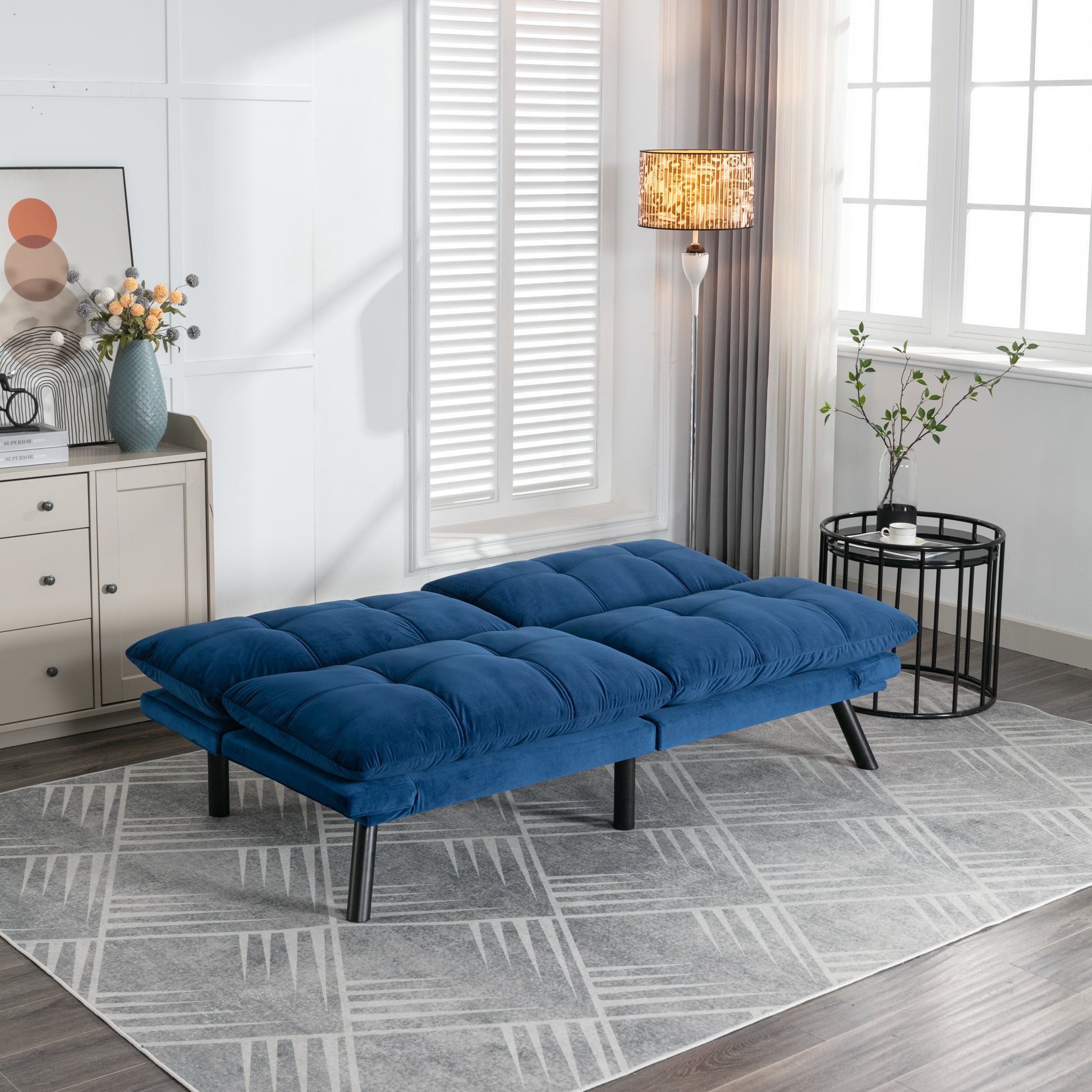 Plush blue velvet futon sofa with tufted cushions perfect for small spaces