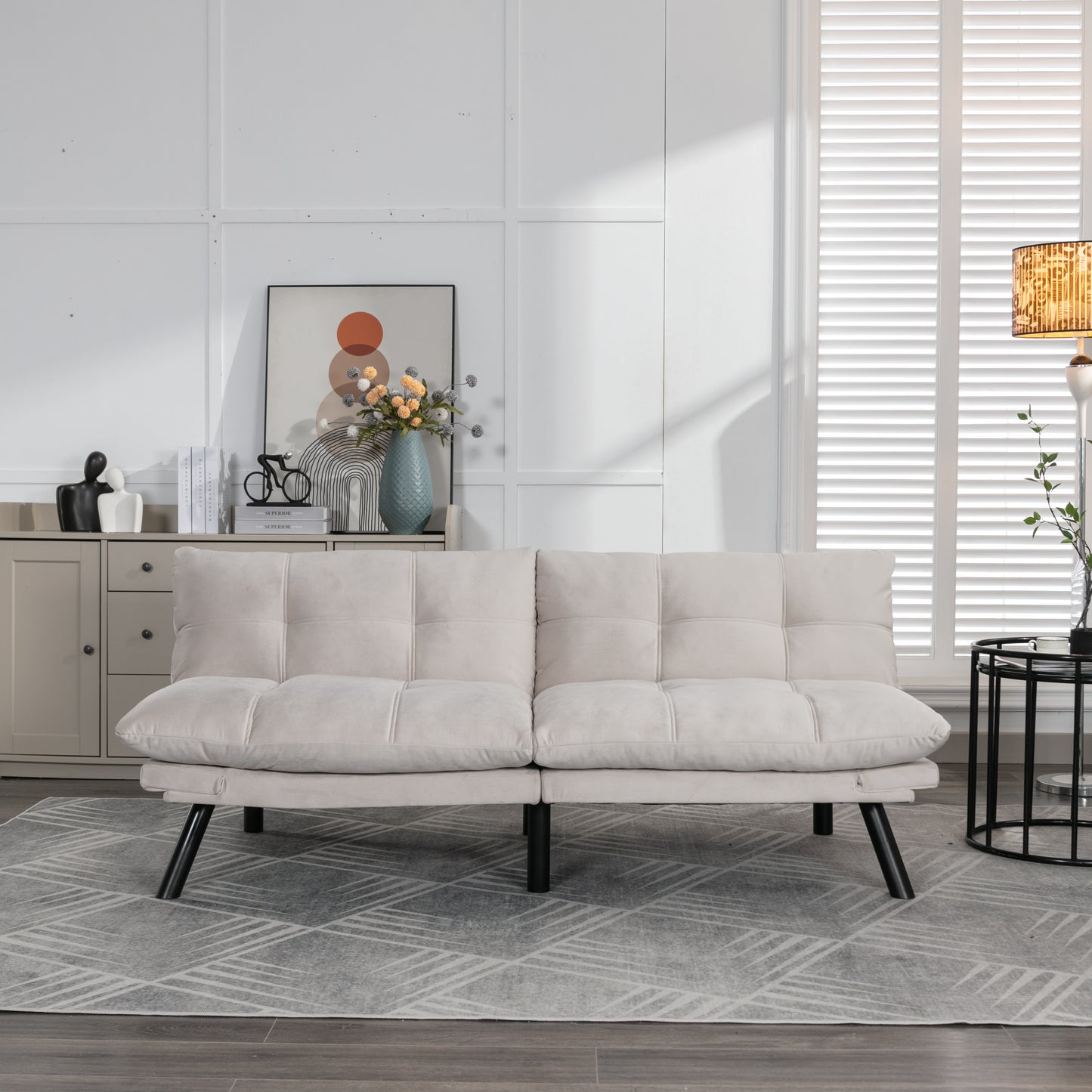 Beige velvet futon sofa with tufted cushions and black legs for a modern living room