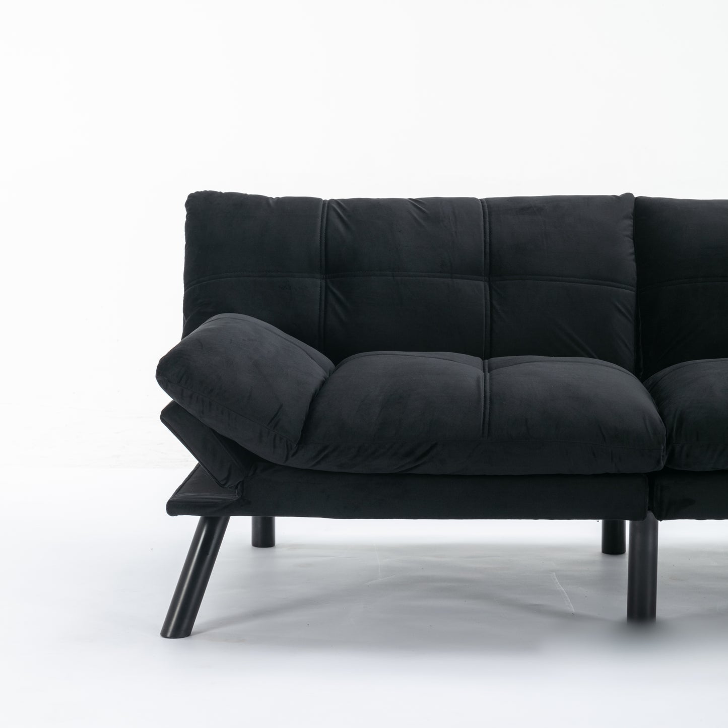 Black velvet futon sofa with quilted seat and adjustable armrest on dark metal legs