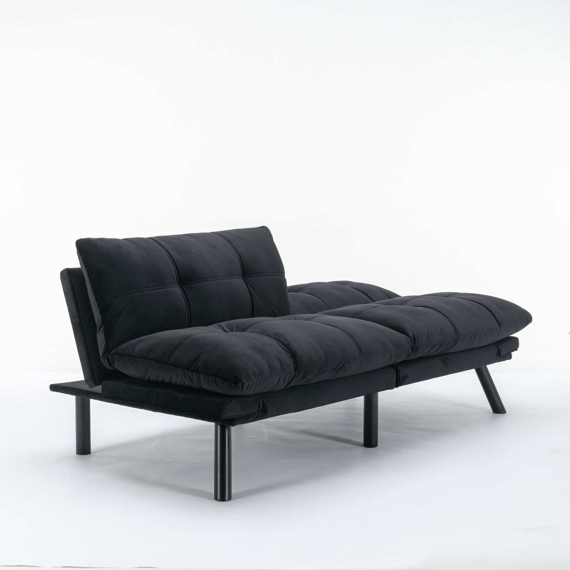 Black velvet futon couch with tufted cushions and dark metal legs