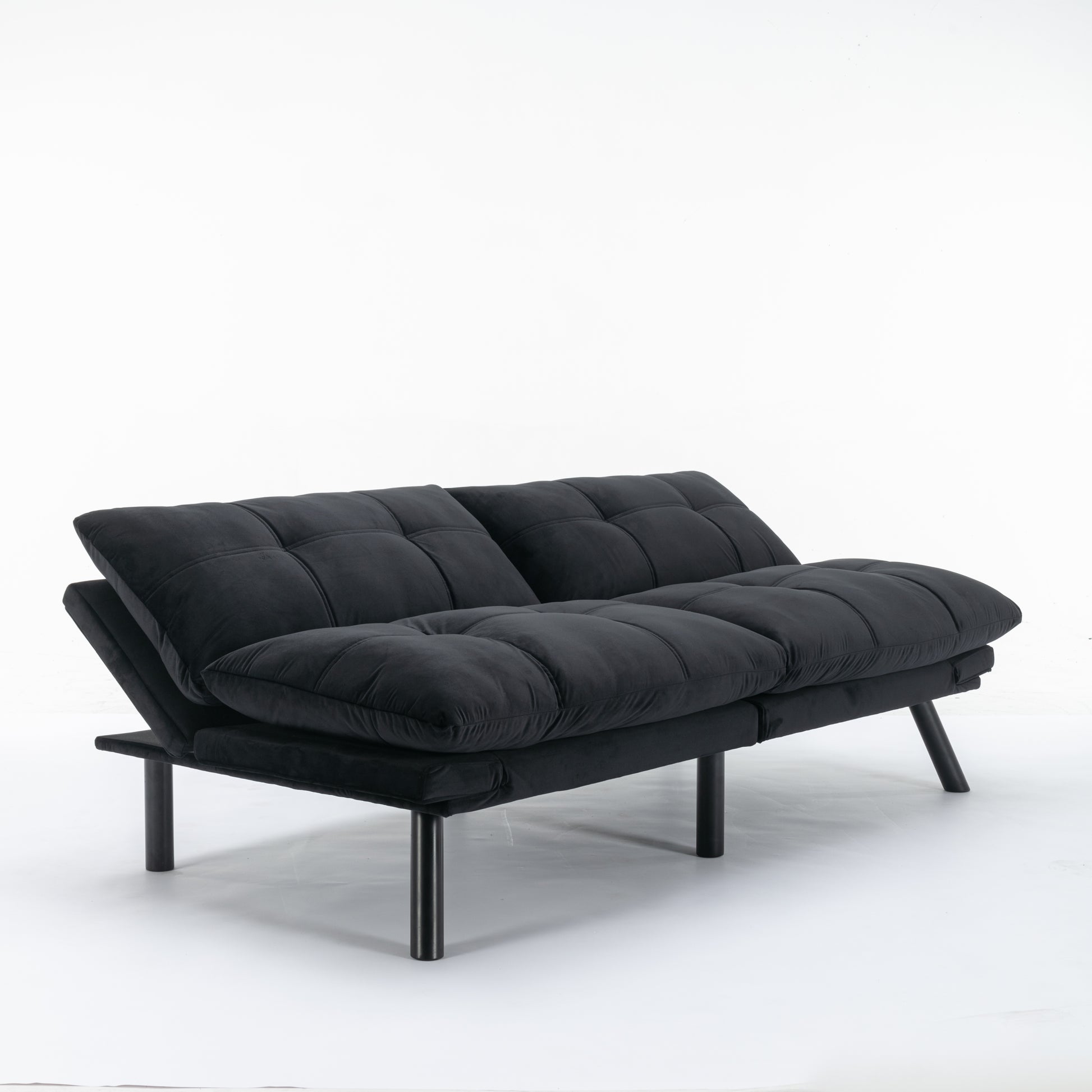 Black velvet futon sofa with tufted cushions and metal legs