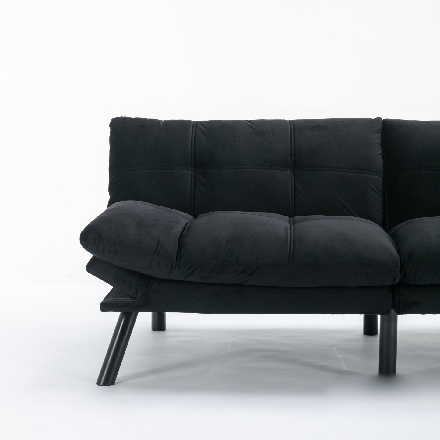 Black velvet futon sofa with tufted cushions and modern metal legs perfect for small spaces