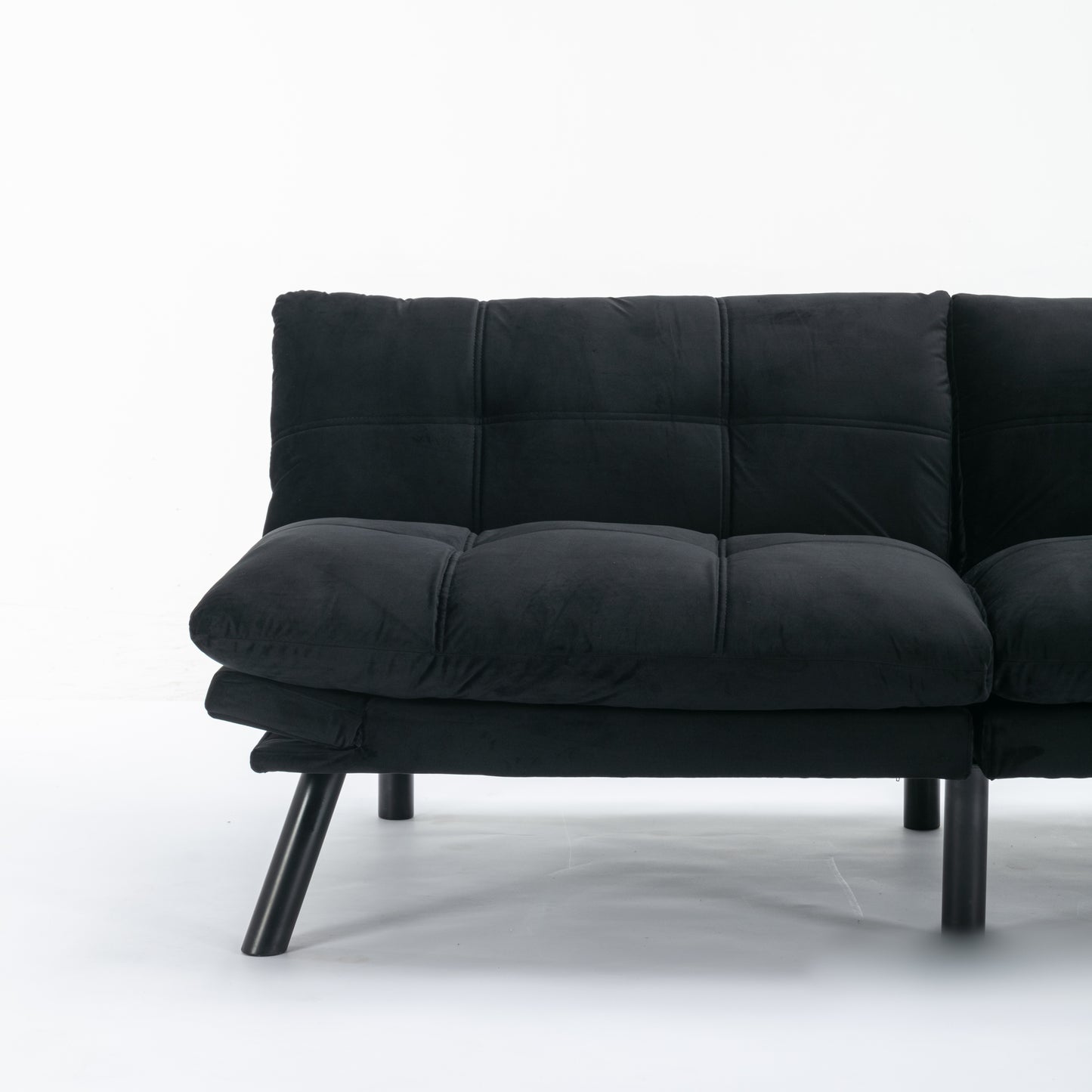Black velvet sofa with tufted cushions and sleek metal legs modern design
