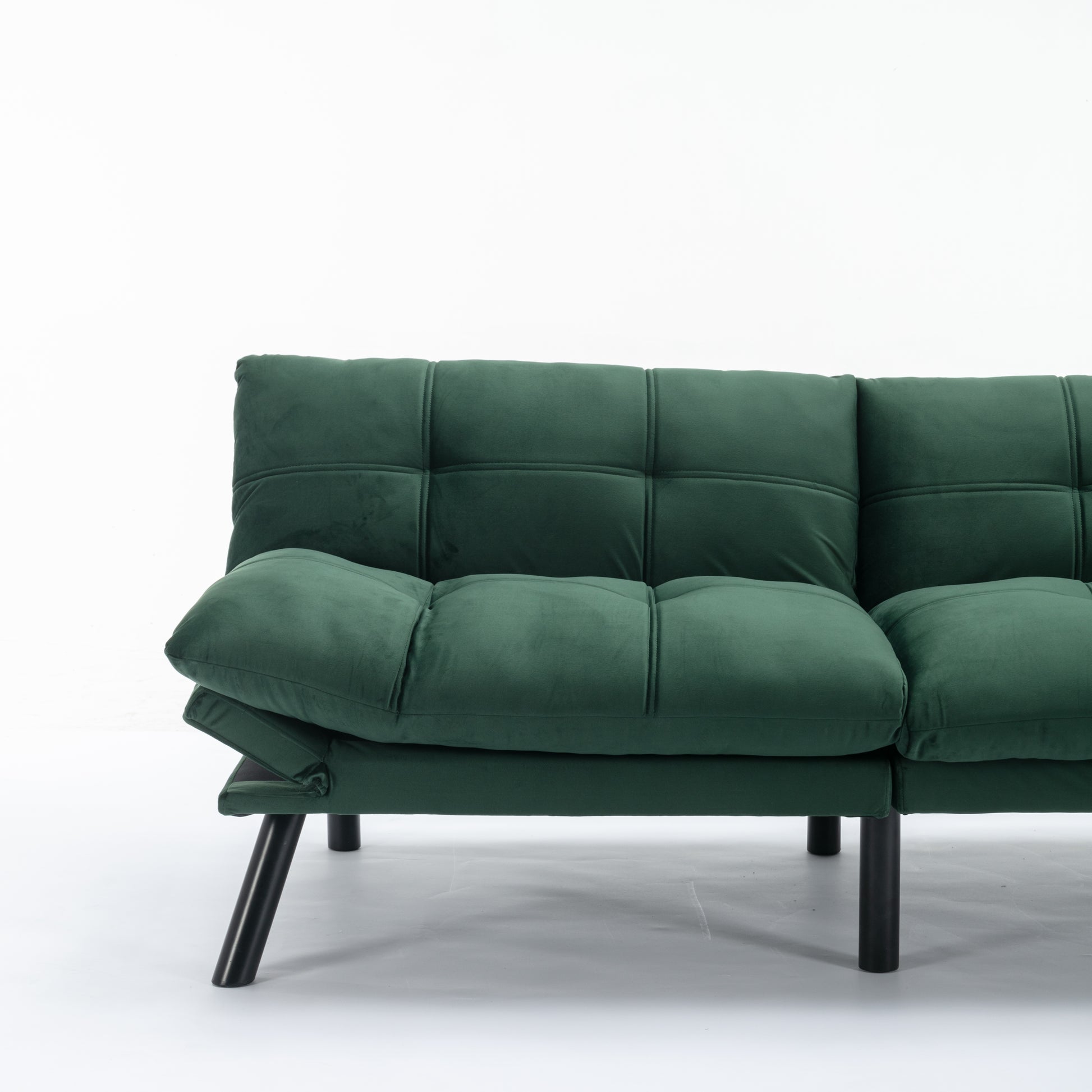 Dark green velvet sofa with tufted cushions and black legs